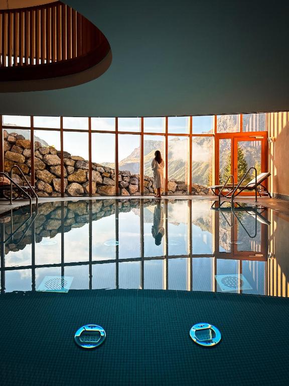 a woman is standing in a swimming pool at Hotel Goldener Berg in Lech am Arlberg
