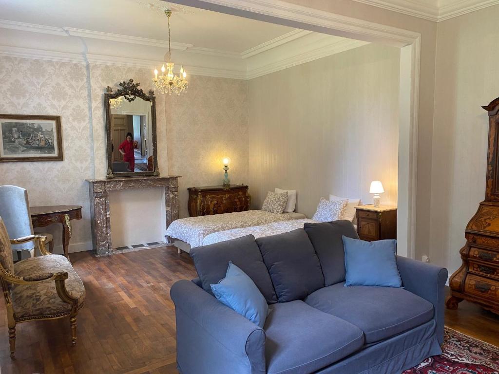 - un salon avec un canapé bleu et un lit dans l'établissement Château de Porcheresse, à Daverdisse