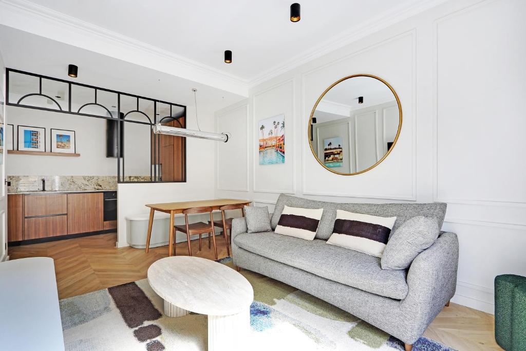 un salon avec un canapé et une table dans l'établissement Pick A Flat's Apartment in Triangle d'Or - Pierre 1er de Serbie, à Paris
