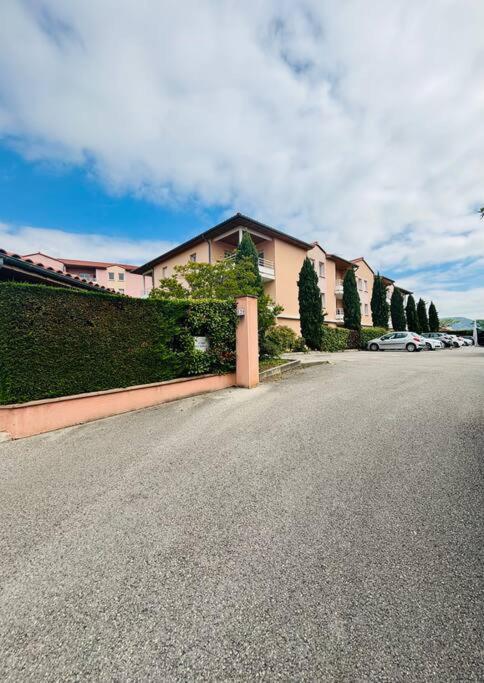 une rue avec une rangée de maisons et une clôture dans l'établissement Appartement, à Millau