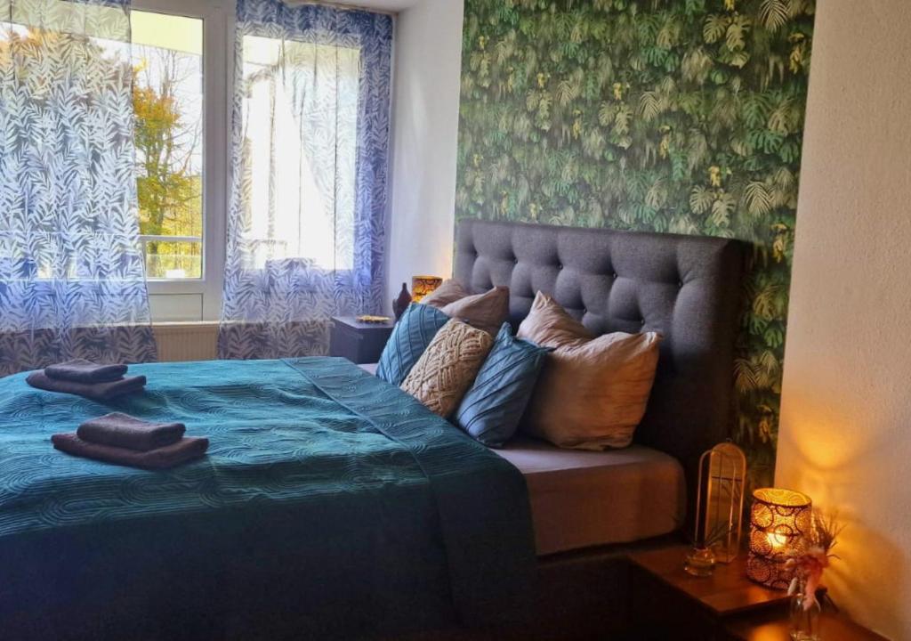 una camera da letto con un letto blu e una finestra di Wald Apartments im Predigtstuhl Resort a Sankt Englmar