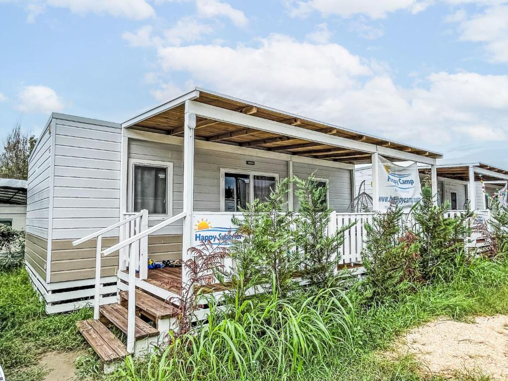 a tiny house with awnings on it at Holiday Home Happy Superior by Interhome in Rosapineta