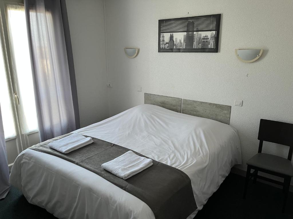 Postel nebo postele na pokoji v ubytování Hôtel Le Lyon Vert Commentry