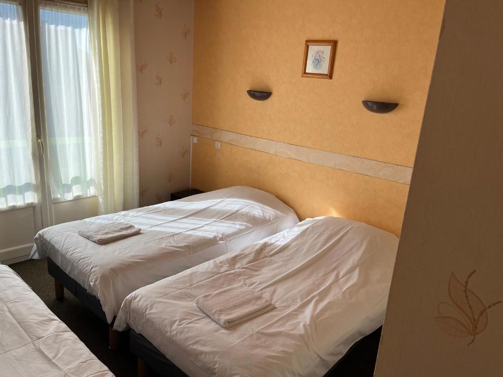 Postel nebo postele na pokoji v ubytování Hôtel Le Lyon Vert Commentry