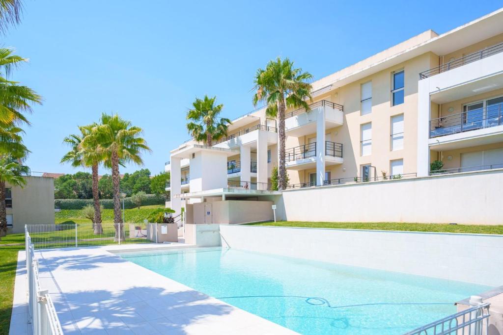 une villa avec piscine et palmiers dans l'établissement Appart haut standing Cannes, à Cannes