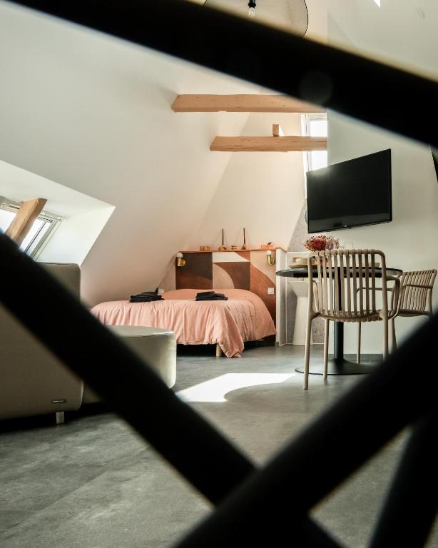 une chambre avec un lit et un bureau avec une télévision dans l'établissement Les toits de la Citadelle, à Belfort