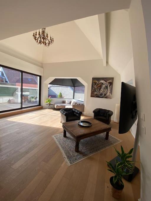 un salon avec une table et une télévision dans l'établissement Les Murmures des Toits - Hypercentre - garage privé, à Colmar