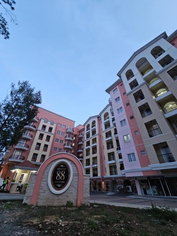 Un cartel delante de unos edificios altos. en Cozy 2BR with Balcony in Mines View Park by Peniel's Getaway, en Baguio