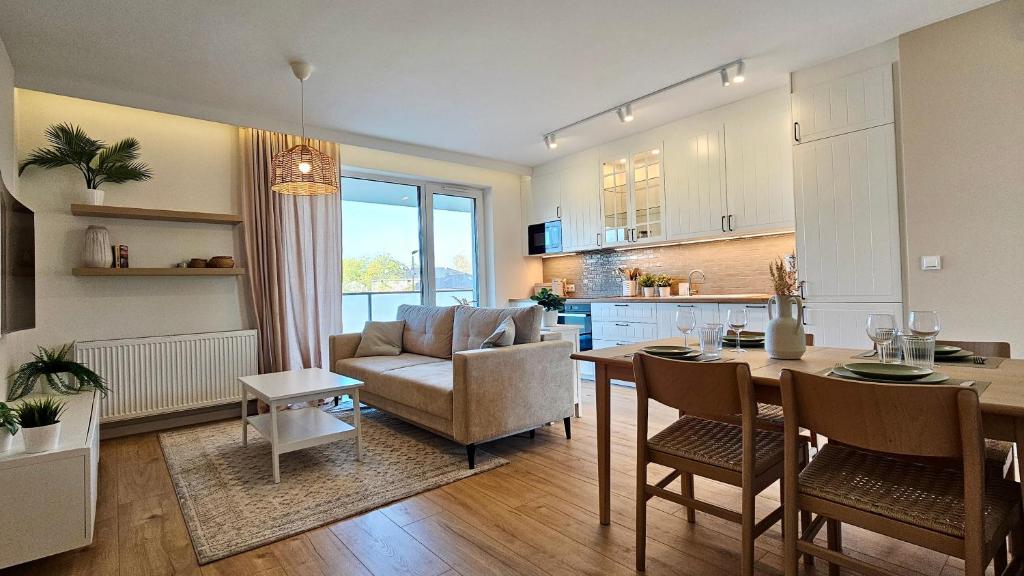 a kitchen and living room with a table and a couch at Green Arches apartment in Łagów