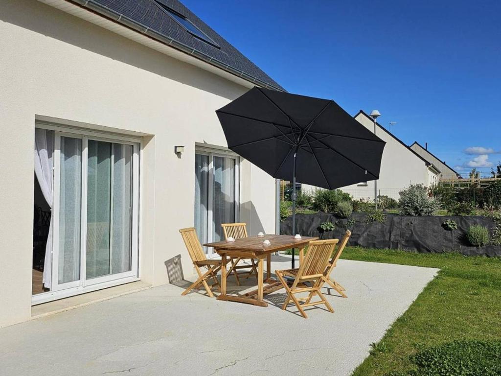 une table et des chaises en bois avec un parasol dans l'établissement Maison neuve à Perros-Guirec avec WIFI, jardin, terrasse, proche plage et bus gratuit - FR-1-368-404, à Perros-Guirec