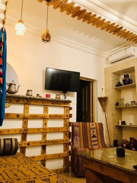 a bedroom with a bed and a tv on the wall at Dar Chahla in Tozeur