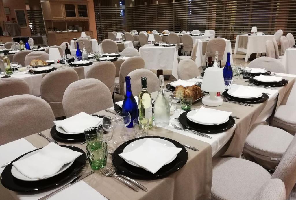 a dining room with tables and chairs with white table settings at Barion Hotel & Congressi in Bari