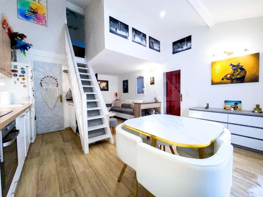 - un salon avec une table blanche et un escalier dans l'établissement Charmante petite maison avec jardin, à Saint-Cézaire-sur-Siagne