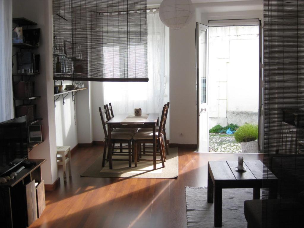 una sala da pranzo con tavolo, sedie e finestra di The Back Yard Nest a Lisbona