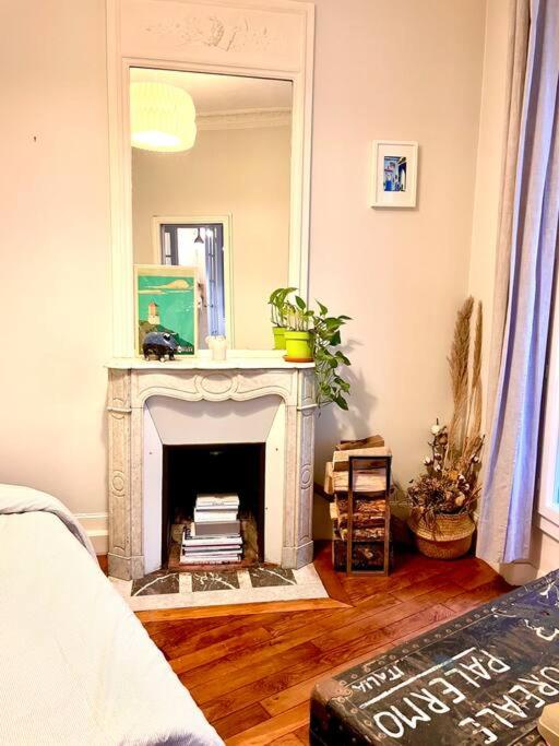 un salon avec une cheminée et un miroir dans l'établissement Apartment Paris - Tour Eiffel - Bail Mobilité, à Paris