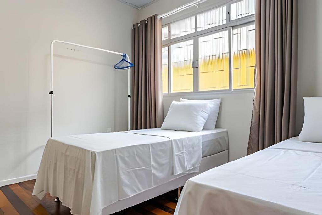 two beds in a room with a window at Casa central em ótima localização - UN059 in Florianópolis