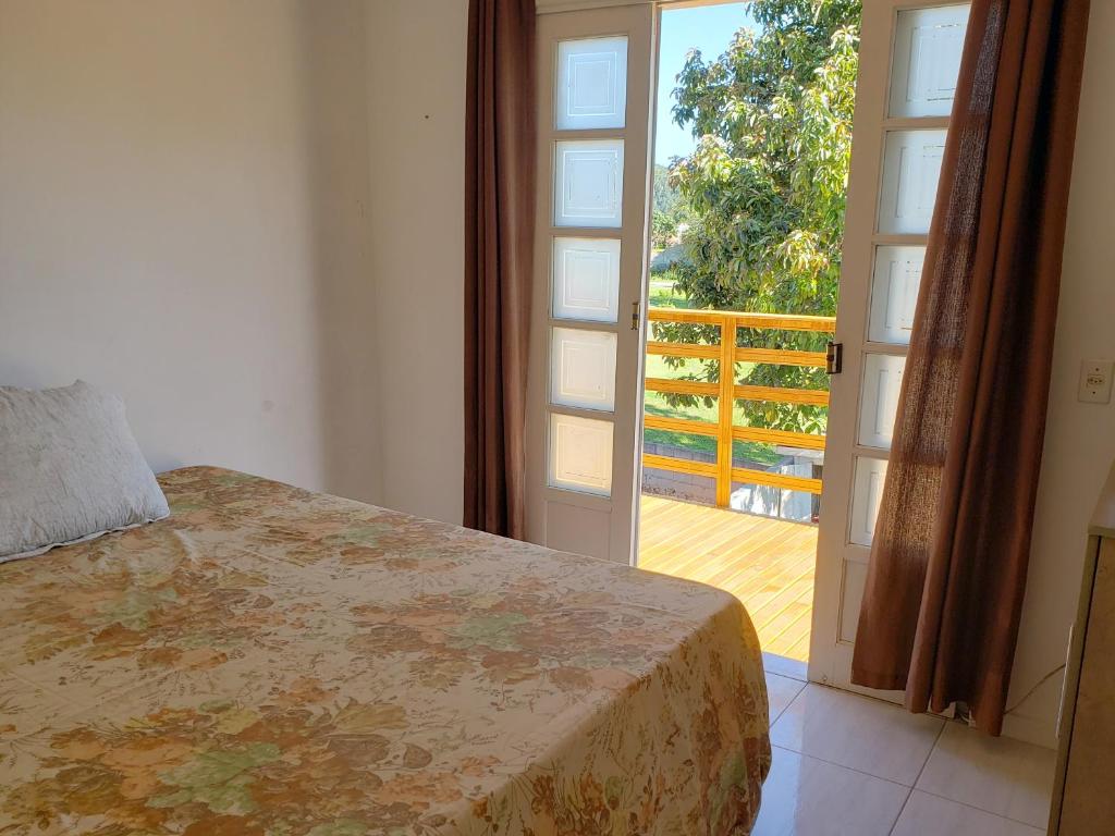 a bedroom with a bed and a door to a balcony at Refúgio Minimalista Tranquilidade a 600m da Praia in Governador Celso Ramos