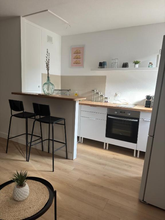 - une cuisine avec un comptoir, 2 chaises et une table dans l'établissement Studio 13005 quartier la timone, à Marseille
