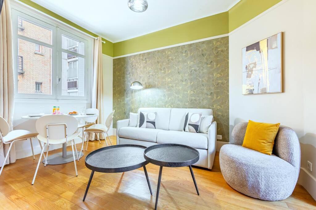 un salon avec un canapé et une table dans l'établissement Confort et tranquillité à Neuilly-sur-Seine, à Neuilly-sur-Seine