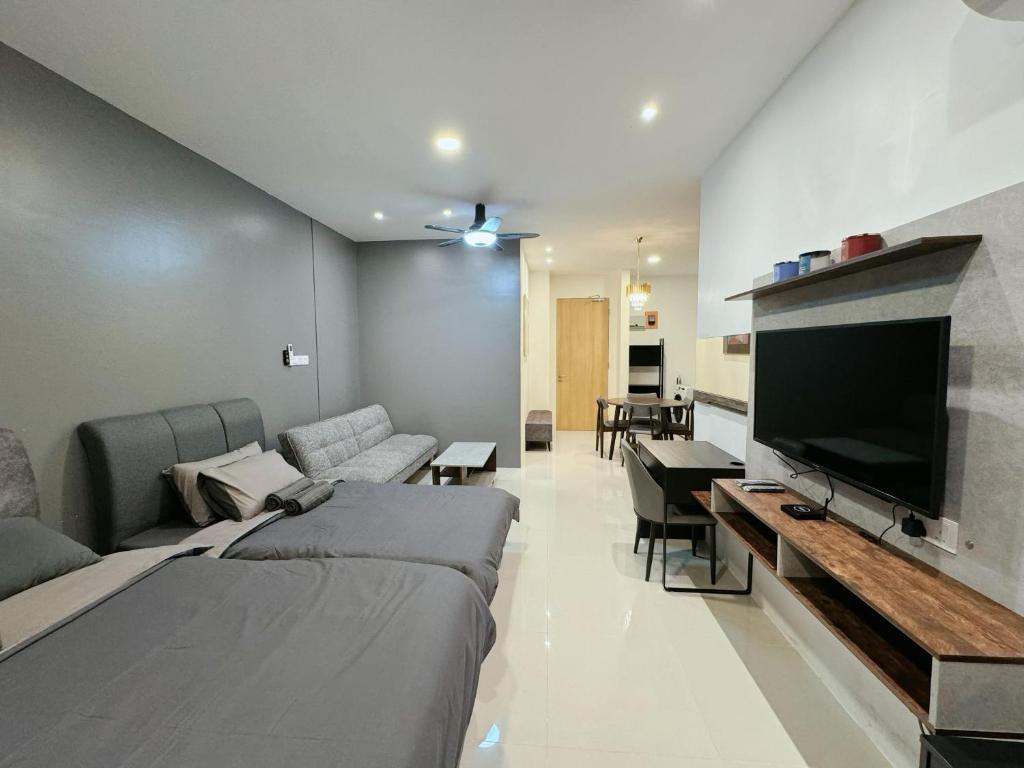 a living room with two beds and a flat screen tv at Kuching Cozy Comfort 03 - Riverine Diamond Kuching 5 Pax in Kuching