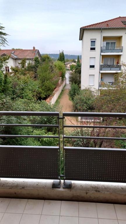 un banc sur un balcon avec un bâtiment en arrière-plan dans l'établissement Bel appartement Type F2 vaux en velin Village 69120, à Vaulx-en-Velin