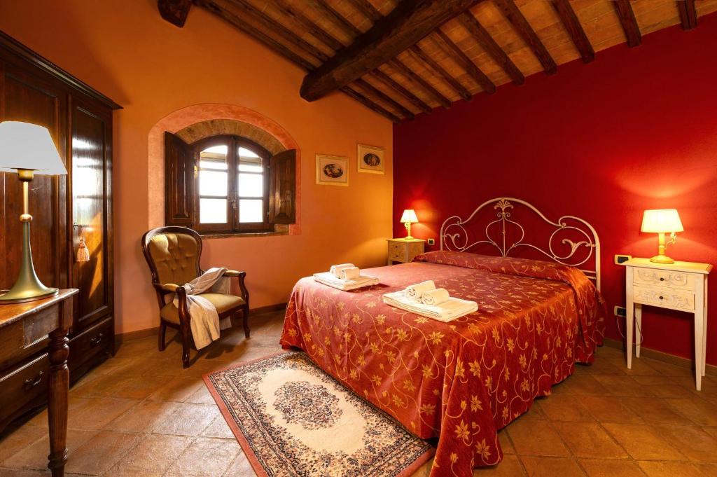 - une chambre rouge avec un lit et une chaise dans l'établissement Villa La Francigena, à San Gimignano