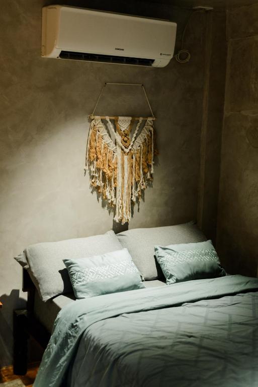 a bed with two pillows and a ceiling at Pantropiko Lodge in El Nido