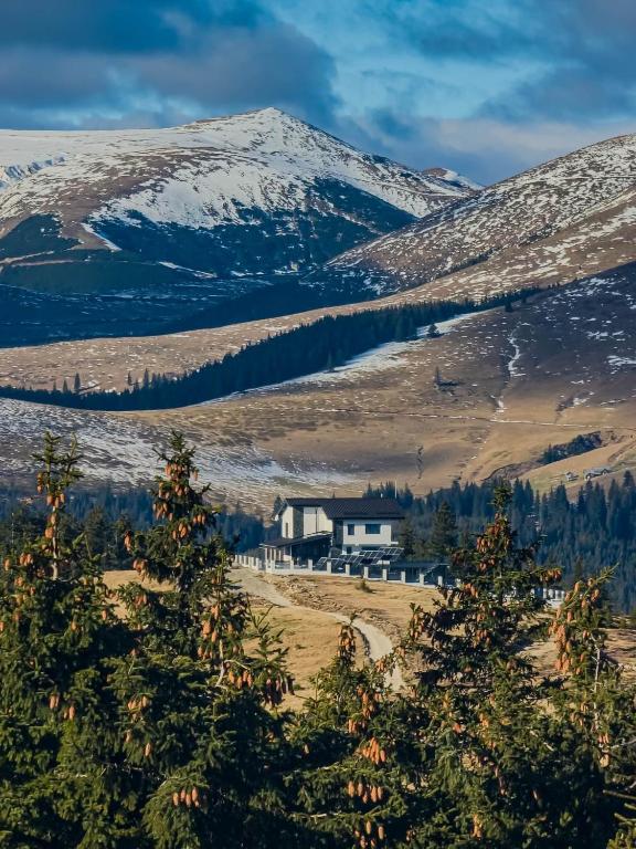 una casa in mezzo a una montagna innevata di Alpine Blu - Horezu - Varful lui Roman - Sauna, Hot Tub & Gym a Horezu