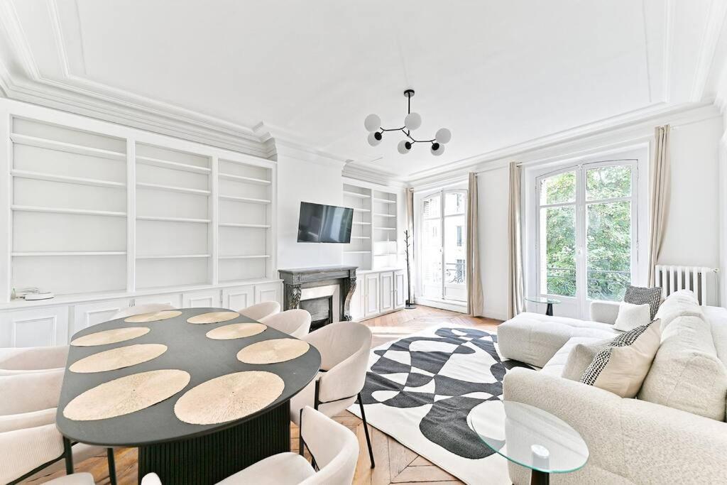un salon blanc avec une table et des chaises dans l'établissement Appartement parisien spacieux #Marais #Rivoli - II, à Paris