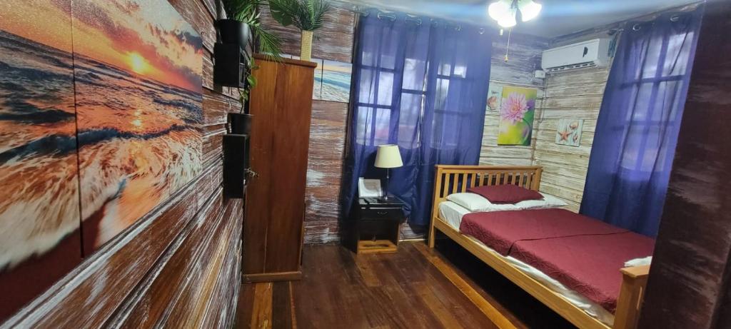 a bedroom with a bed and a painting on the wall at Hotel Tierra Verde Bed and Breakfast in Bocas del Toro