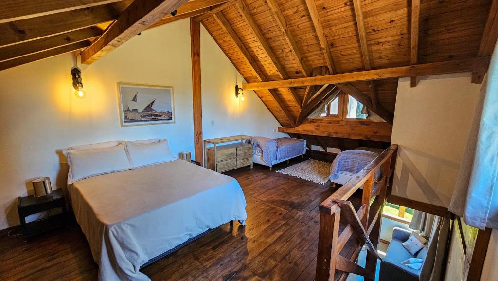 a bedroom with a bed and a wooden ceiling at Cabaña La Calandria in San Carlos de Bariloche