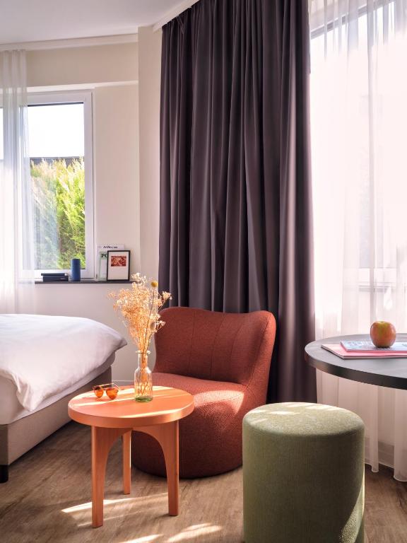 a bedroom with a bed and a couch and a table at STAYERY Cologne Sülz - Uni-Center in Cologne