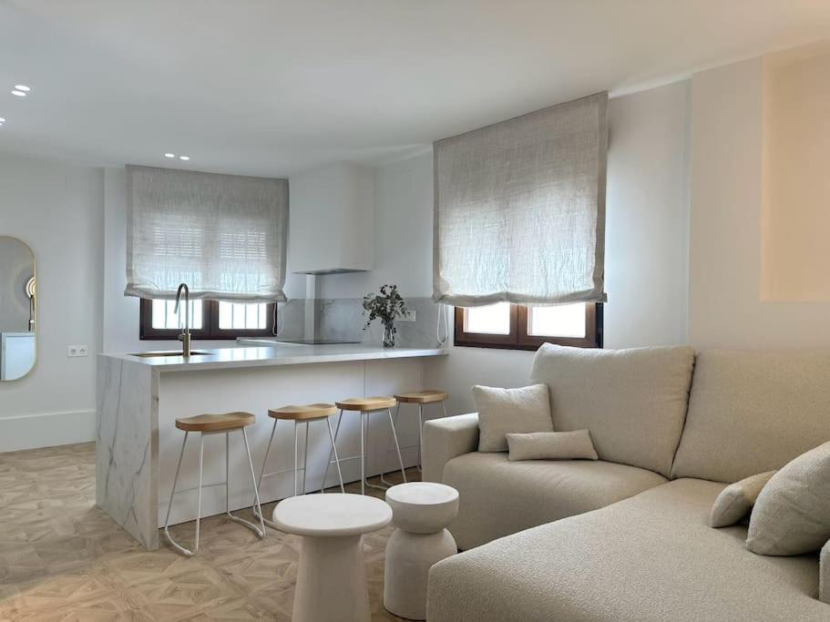 a living room with a couch and a kitchen at Soleá Apto en centro de Alhama in Alhama de Granada