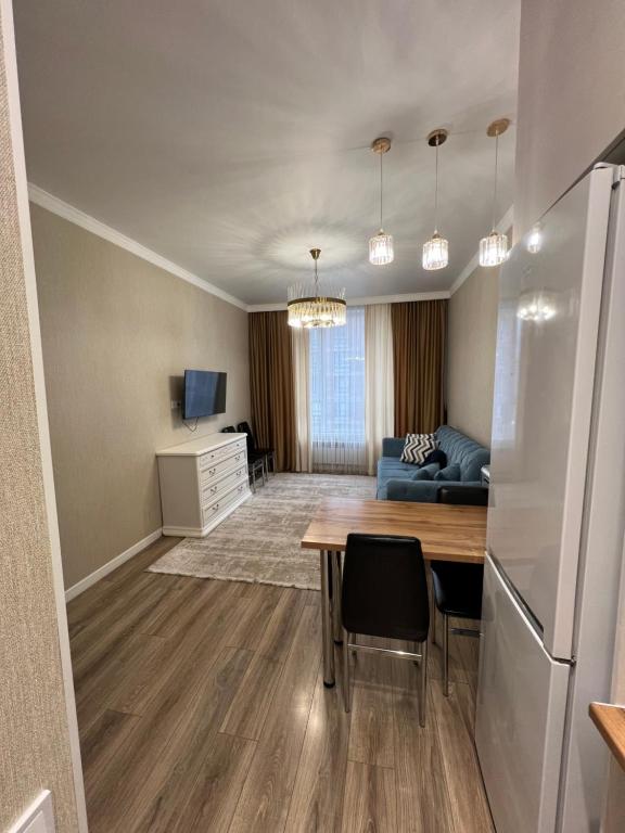 a living room with a table and a couch at Квартира in Taldykolʼ