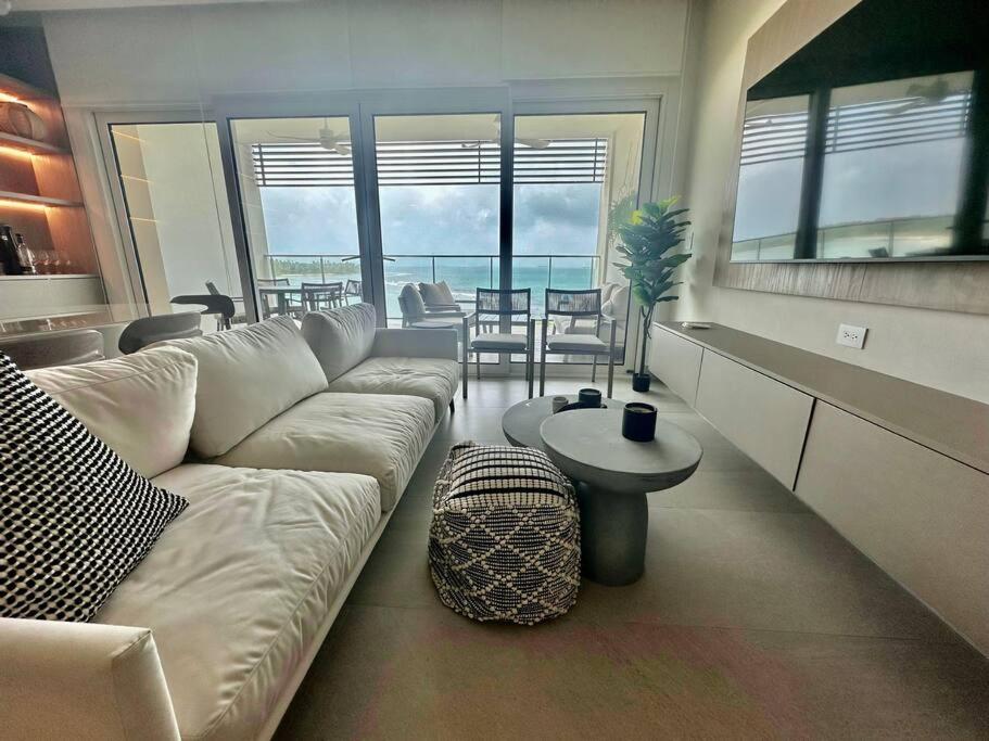 a living room with a white couch and a table at Elegant 5-Bedroom Apartment in Exclusive Playa Escondida Pet Friendly in María Chiquita