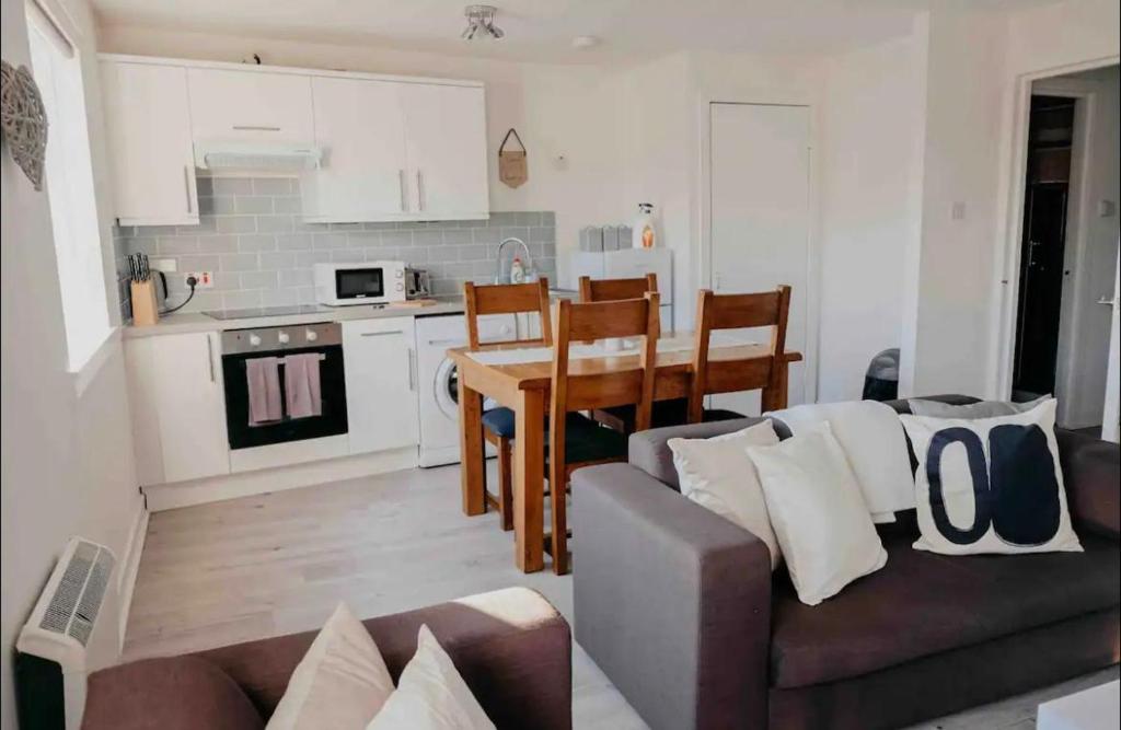 a living room and kitchen with a couch and a table at Glasgow City - 1 Bedroom Apartment in Glasgow