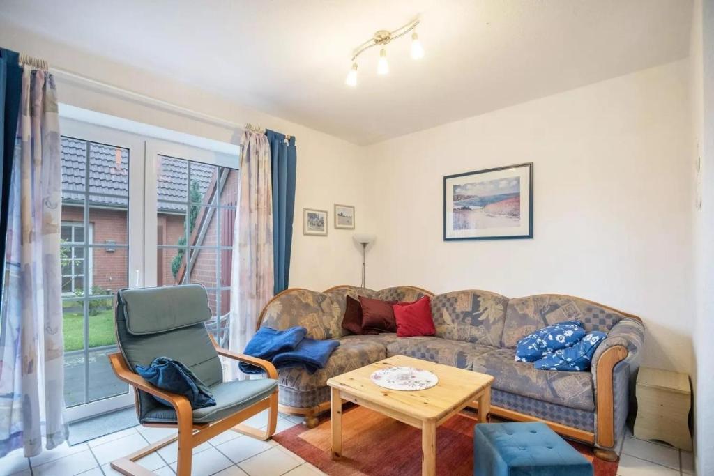 a living room with a couch and a chair at Haus Clara in Neßmersiel