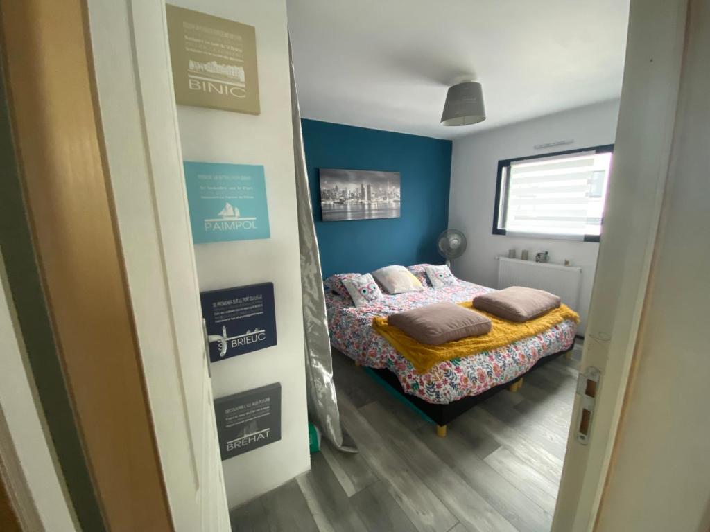 een slaapkamer met een bed met kussens erop bij Maison Koh Tao - Chambre chez l habitant - in Langueux