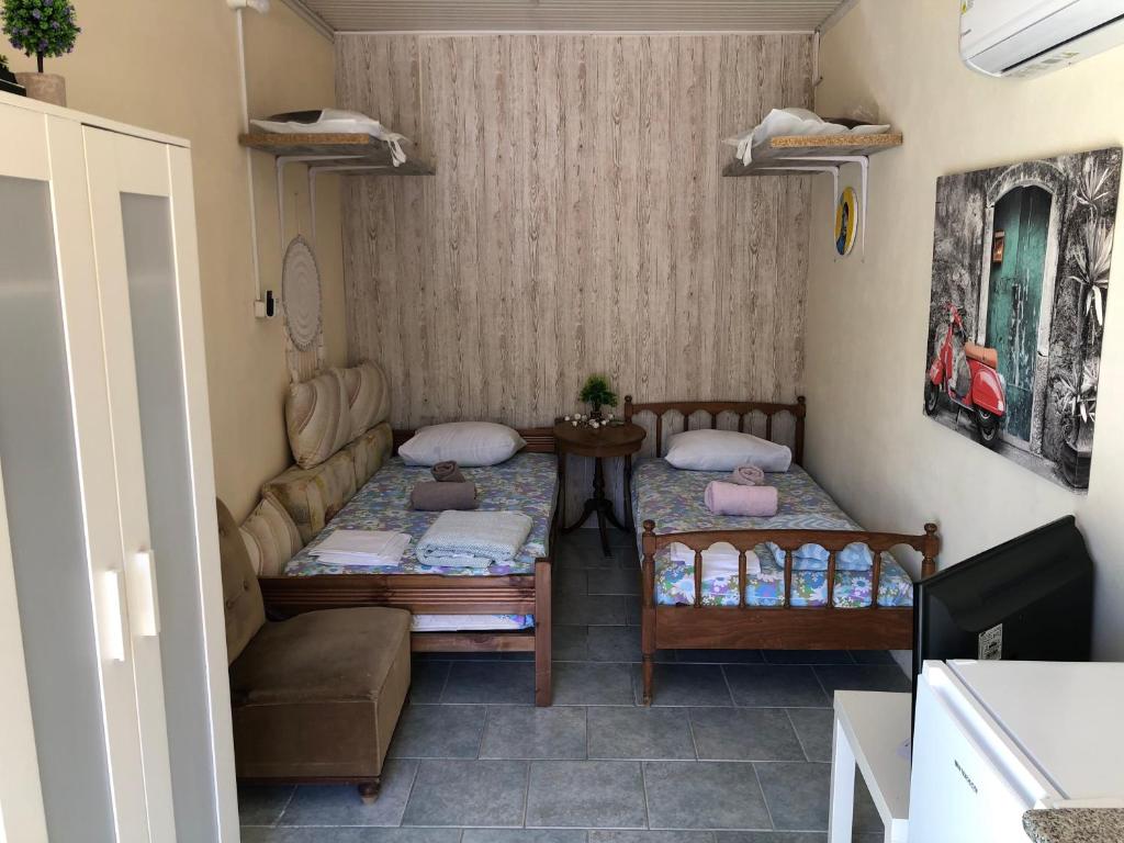 a small room with two beds and a couch at Converted Shed Studio & Garden Hanging Bed in Porto Rafti