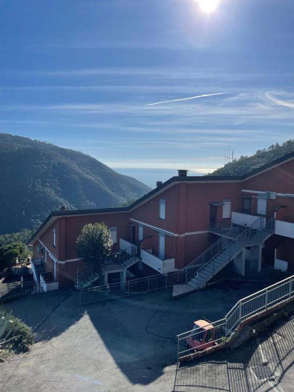 een groot rood gebouw met een heuvel op de achtergrond bij da Paolone in Deiva Marina