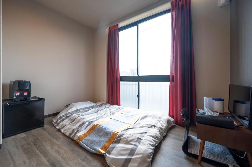 坂出市にあるRENT building - Vacation STAY 14181vのベッドと机と窓のある寝室