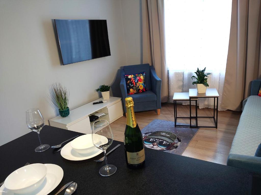 eine Flasche Wein auf einem Tisch in einem Wohnzimmer in der Unterkunft Avanti Apartments in Białystok