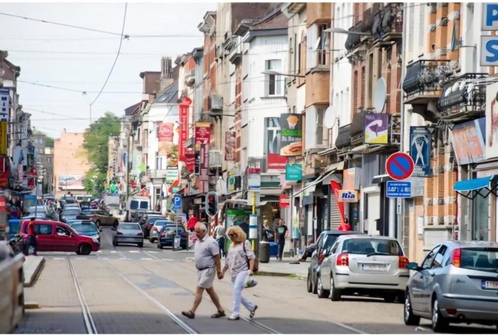 two people crossing a busy city street with cars at appartement douvres in Brussels