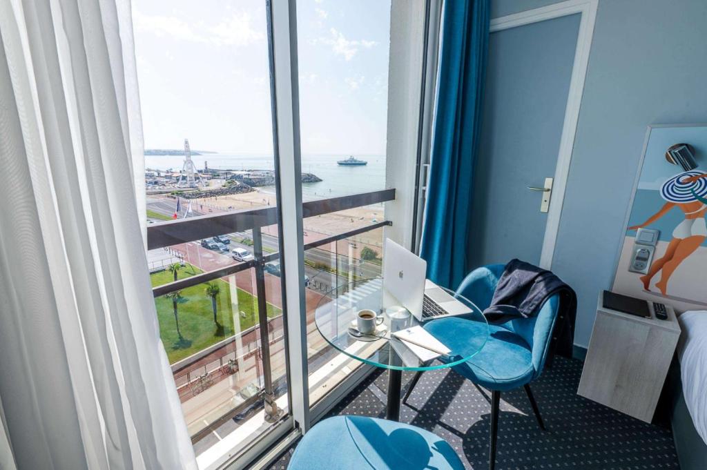 a hotel room with a glass table and a window at Best Western Hôtel Royan Océan in Royan