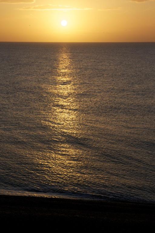 an image of the sun setting over the ocean at The Brudenell in Aldeburgh