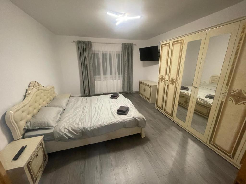 a bedroom with a bed and a large mirror at Apartament Zarnesti in Zărneşti