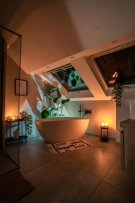 La salle de bains est pourvue d'une baignoire avec des plantes sur le mur. dans l'établissement LE RABELAiS, à Chinon