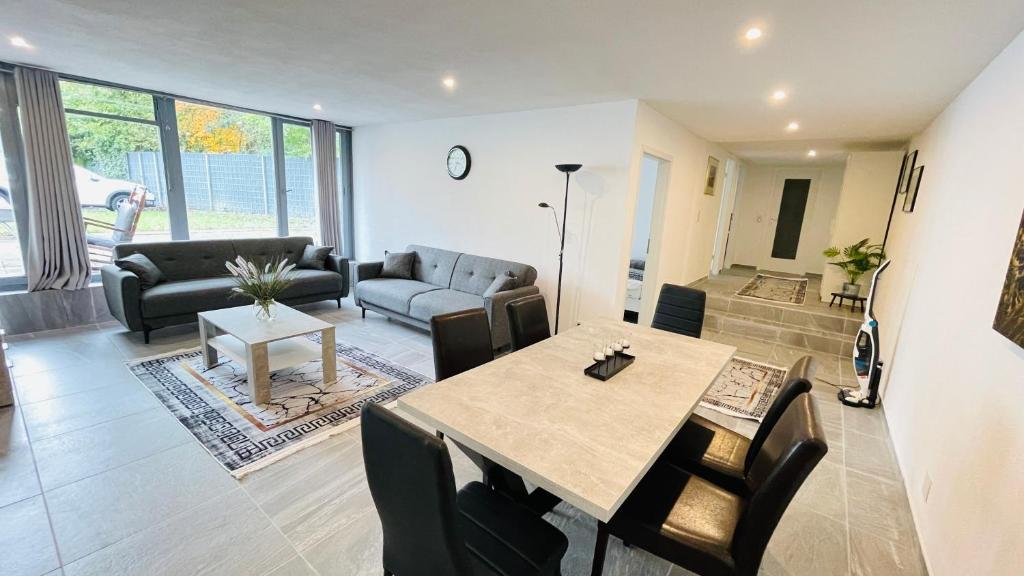 Una sala de estar con una mesa y sillas y un sofá. en Kami Haus, en Saarbrücken