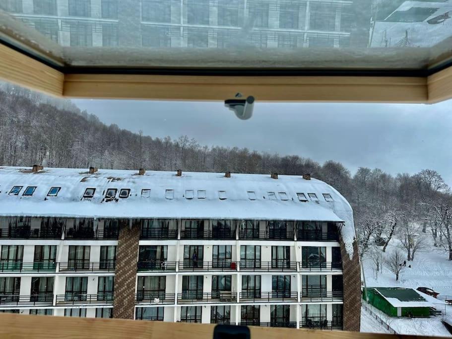 a view of a building with snow on the roof at Bakuriani Haystack Apartment 219 Rooftop Views in Bakuriani