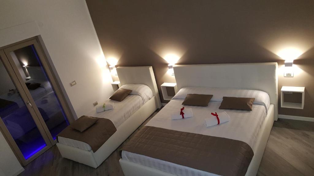 a small bedroom with two beds and a mirror at La Lira in Fiumicino